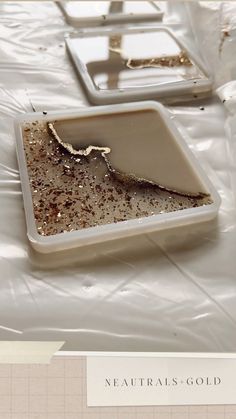 there are two trays that have been covered with plastic and gold flakes on them