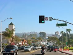 a traffic light that is green on a city street with cars driving down the road