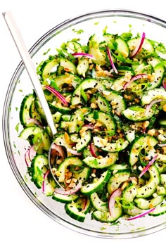 a glass bowl filled with cucumbers and onions