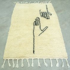 a white rug with black writing on it and tassels hanging from the side