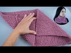 a woman is holding up a pink crocheted blanket with her hand on it