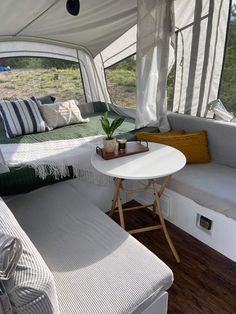 the inside of a camper with a table and couch