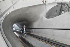 a man riding an escalator up the side of a building