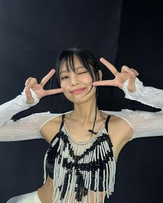 a woman with her hands in the air and wearing a beaded top over her head