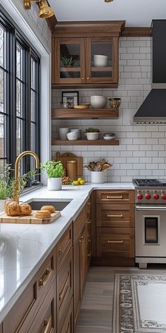 a kitchen with wooden cabinets and stainless steel appliances, along with white marble countertops