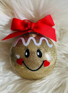 a gold ornament with a red bow on it's head and eyes