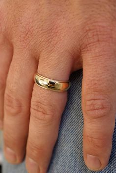 a man's hand with a gold ring on it