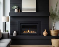 a living room with a fire place next to a couch and two vases on the table