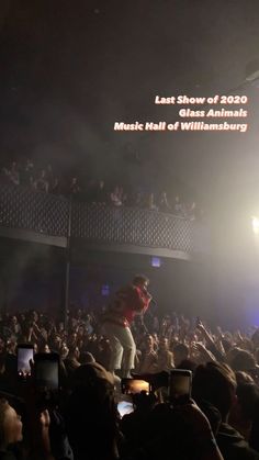 a man standing on top of a stage in front of a crowd