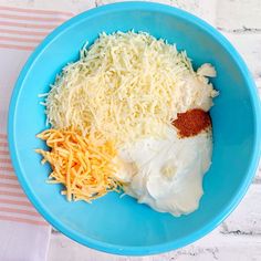 a blue bowl filled with cheese and sour cream