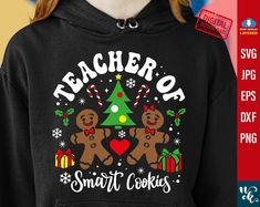 a black hoodie with two gingerbreads and a christmas tree on it that says teacher of santa cookies