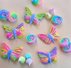 there are many different colored butterflies on the table, and one is made out of fondant