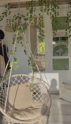 a white hanging chair with green plants on it