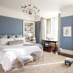 an image of a bedroom with blue walls and chandelier hanging from the ceiling