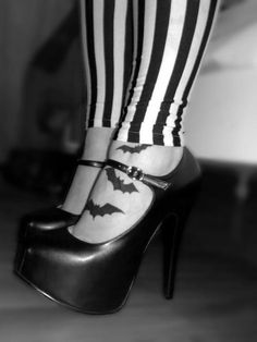 black and white photo of woman's legs with bat tattoo on their leggings