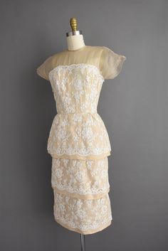 "Outstanding vintage 1950s cocktail party dress by Irene Sargent. This vintage dress features a wonderful Chantilly lace over lace with a gorgeous tier pencil skirt. The bodice is well fitted with bust darts, nipped waist, and a back metal zipper for closure. ✂------ M E A S U R E M E N T S ------- Best Fit: Small Bust: 32.5/33\" Waist: 24.5/25\" Hips: 37.5\" Shoulders: undefined Sleeves: 3.5\" Total Length: 44.5\" Tag/Label: Irene Sargent Material: Chantilly lace, silk Condition: Excellent vint Cream Lace Dress For Party With Delicate Detailing, Cream Delicate Lace Dress For Party, Vintage Beige Lace Dress For Party, Lace Tea-length Dress For Vintage Events, Elegant Vintage White Dress With Scalloped Lace, Cream Fitted Lace Dress For Garden Party, Cream Scalloped Lace Dress For Evening, Cream Scalloped Lace Evening Dress, 1950s Fitted Dress With Lace Trim