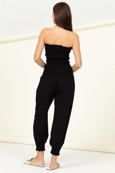 ONLINE EXCLUSIVE Elevate your style game with our Let Love Smocked Top and Trousers Set. The top boasts a flattering straight neckline and a tube silhouette, while the all-over smocked bodice adds a touch of chic texture. Tight ruffle details on the neck and hem add a playful twist to this fashionable ensemble. Paired with the smocked high-waist trousers, which cinch at the bottom cuffs for a tapered look, this set is the perfect combination of comfort and style. Imported. Designed in the USAMod Casual Fitted Smocked Top With Elastic Waistband, Fitted Casual Smocked Top With Elastic Waistband, Casual Non-stretch Strapless Tube Top, Casual Smocked Top With Stretch Elastic Waistband, Fitted Smocked Top With Elastic Waistband, Black Smocked Back Bottoms For Summer, Casual Sleeveless Tube Top For Loungewear, Summer Black Bottoms With Smocked Back, Casual Tube Top With Elastic Waistband For Day Out