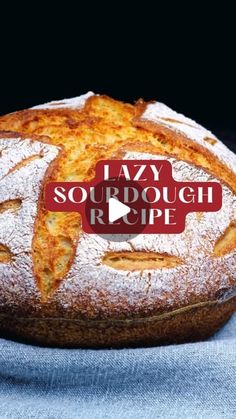 a loaf of sourdough bread sitting on top of a blue cloth covered table