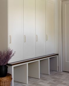 a room with white cupboards and a basket on the floor in front of it