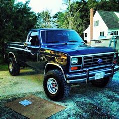 a black pickup truck parked in front of a house