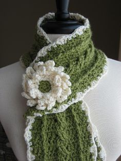 a green and white crocheted scarf on a mannequin