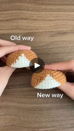 two hands holding crocheted objects on top of a wooden table