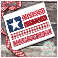 an american flag applique is shown on a wooden surface with red, white and blue ribbons