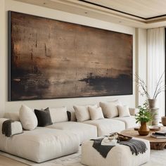 a living room filled with white furniture and a large painting on the wall above it