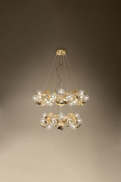 a modern chandelier with glass balls hanging from it's center and gold accents