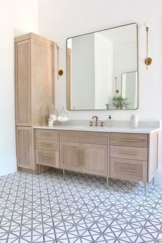 a bathroom with a sink, mirror and cabinets on the wall next to each other