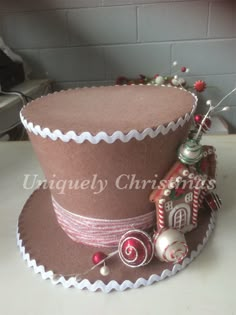 a brown top hat with candy decorations and ornaments on the side, sitting on a table