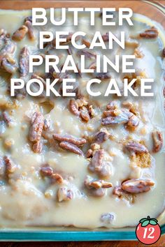 a pan filled with cake covered in pecans and frosting on top of a wooden table