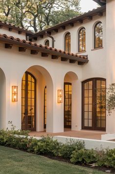 a white house with brown trim and arched windows