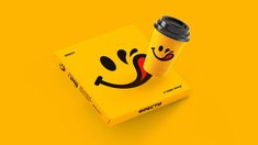 a coffee cup sitting on top of a yellow box