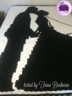 a crocheted blanket with a black and white silhouette