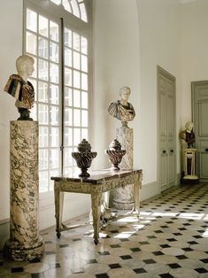 there are many statues on the table in this room, including busturines and vases