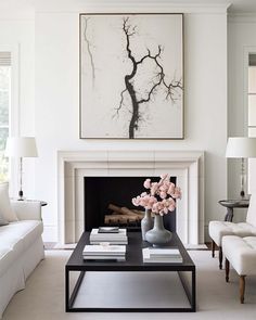 a living room filled with furniture and a painting on the wall over a fire place