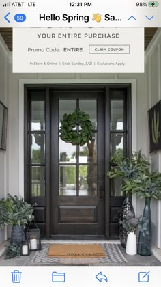 the front door is decorated with potted plants and an entry mat that says hello spring