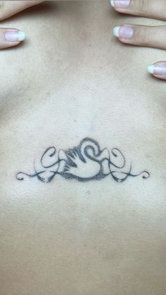 a woman's chest with an intricate tattoo design on her left side ribcage