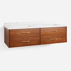 the double sink cabinet is made from wood and has two white marble counter tops with brass handles