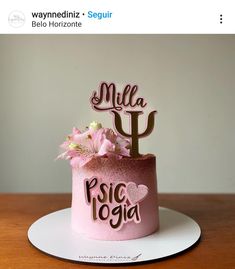 a pink cake with a cactus topper and flowers in the middle on a white plate