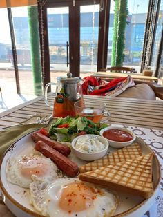 a plate with eggs, sausage and waffles on it sitting on a table