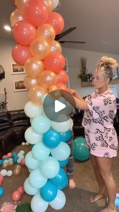 a woman standing next to a bunch of balloons