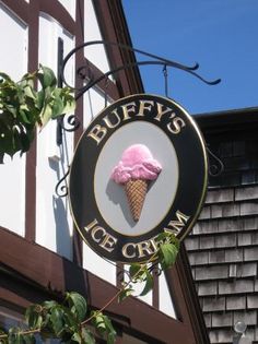 an ice cream sign hanging from the side of a building