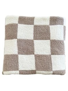 a brown and white checkered pillow on a white background