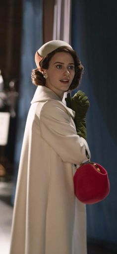 a woman dressed in white holding a red bucket