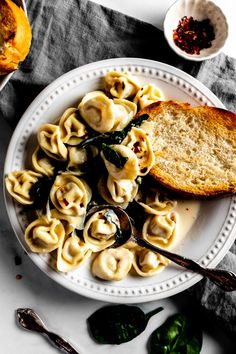 a white plate topped with pasta and bread