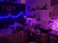 a bedroom with purple lights and pictures on the wall