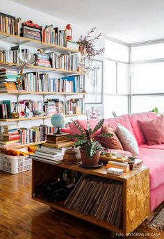 a living room filled with lots of books and furniture