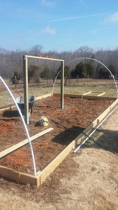 the garden is being built in the middle of an empty field with fencing around it